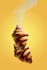 Croissant in levitation with flour or powdered sugar. Freshly baked croissant for breakfast with...