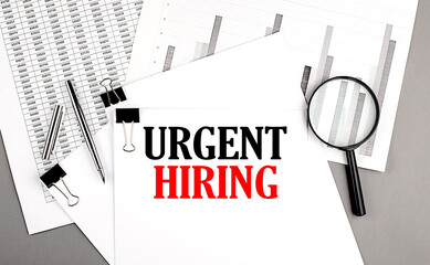 URGENT HIRING text on paper on chart background