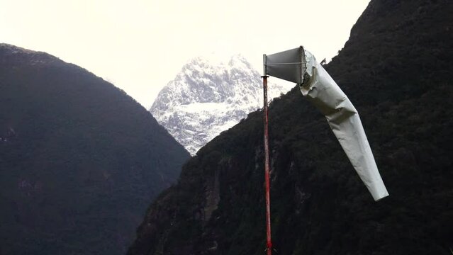 Close up gimbal shot of windsock moving with wind, Mt. Pembroke in background