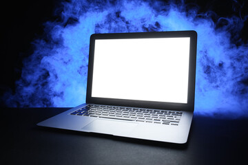 Modern laptop with blank screen and smoke on black background