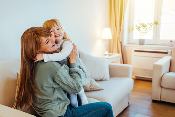 Mother and daughter enjoying together. Shot of a young mother and her daughter spending quality time together at home. Young woman and small girl having a great time together