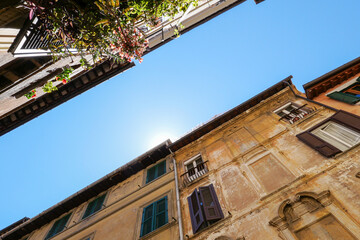 An Italian Street, view of the sky from below: you can see the houses on both sides of the street,...