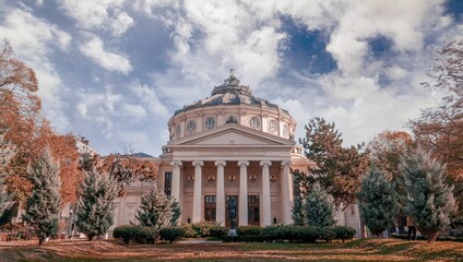 Scenic view of the Romanian Athenaeum with a beautiful garden under the cloudy sky
