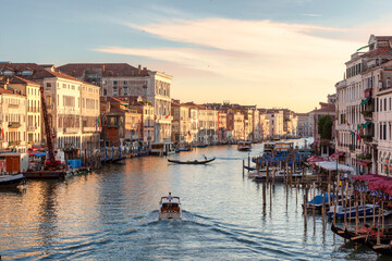 Venezia.. Veduta dei palazzi sul Canal Grande con gondola e motoscafo dal Ponte di Rialto al tramonto - obrazy, fototapety, plakaty