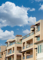 Vertical White puffy clouds Residential buildings with glass railings at La Jolla, Californi