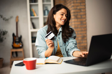 Pregnant woman shopping online at home. Happy woman with laptop and credit card..