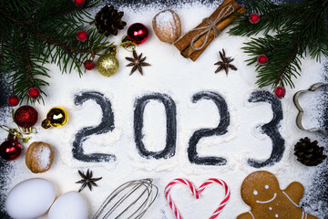 The concept of baking Christmas cookies. Christmas decor, the number 2023 written on flour and...