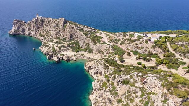 Aerial drone video of famous archaeological site of Heraion in Cape Melagavi featuring a small beach next to iconic lake Vouliagmeni and lighthouse, Corinthian bay, Perachora, Loutraki, Greece