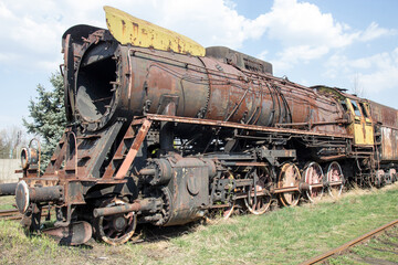 Old rusty crumbling locomotive in the abandoned station