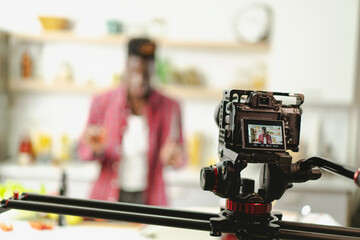 African man filming cooking vlog. Happy man filming his blog about healthy food at home..
