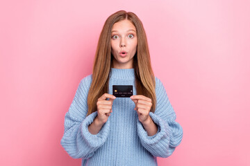 Photo of youngster teen girl wear knitted blue sweater pouted lips shock hold new debit card high profit percent isolated on pink color background