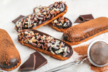 Delicious chocolate eclairs on table, closeup