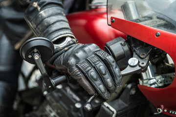 Fototapeta na wymiar Hand in safety glove on motorcycle handlebar