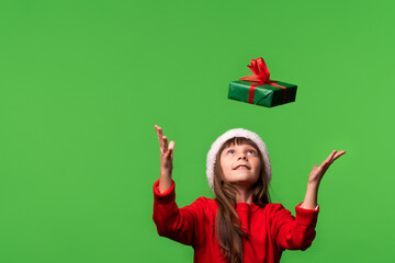 Gifts fall into hands. Black Friday concept, sale, promotion, big discounts. A little funny girl in a Santa hat catches a gift with her hands. Merry Christmas and Happy New Year 2023