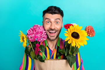 Photo of astonished positive person toothy smile unbelievable floral bag isolated on teal color...