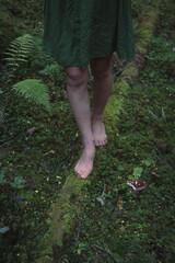 Close up forest log and feet concept photo. Shoeless woman. Side view photography with green forest ground on background. High quality picture for wallpaper, travel blog, magazine, article