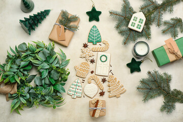Composition with Christmas cookies, decorations, gifts and wreath on light background