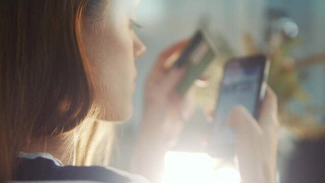 girl pays for purchases online shopping with a debit card in a smartphone. online store shop e-commerce concept. girl makes purchases in a web store with internet a debit card. online shopping