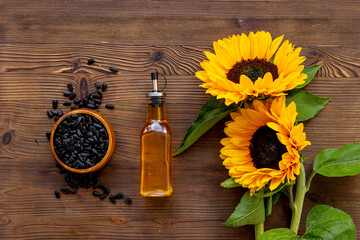 Fototapeta premium Blooming yellow sunflowers with cooking oil and black seeds, top view