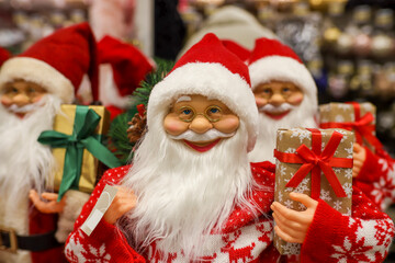 Group of Santa Claus toy figures holding a gift box in their hands