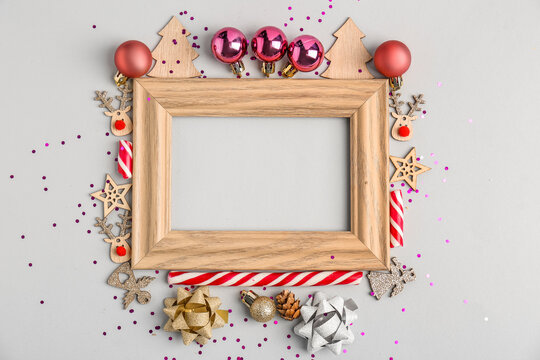 Composition with empty picture frame and Christmas decorations on white background