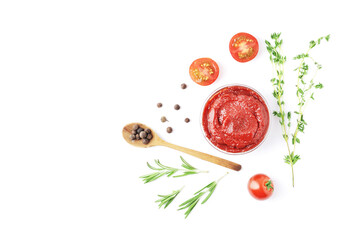 Composition of a bowl full of tomato sauce, spices, condiments and other ingredients on a white background. A bowl full of tomato sauce. Fragrant rosemary and thyme. 