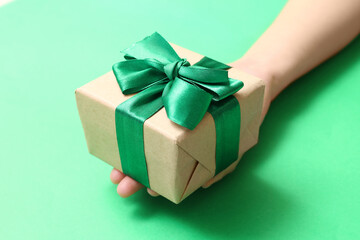 Woman with beautiful Christmas gift on green background, closeup