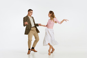 Young excited man and woman in 60s american fashion style clothes dancing retro dance isolated on...