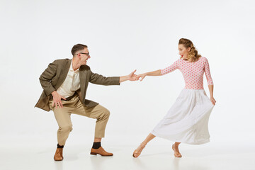 Young excited man and woman in 60s american fashion style clothes dancing retro dance isolated on white background. Music, energy, happiness, mood, action