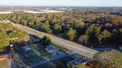 Fototapeta na wymiar Residential area single family homes situated woodland lush green tree from Bogan Park and warehouse buildings in background Buford, Georgia, US