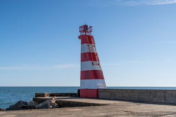 Red and white Lighthouse on pier
