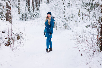 a lonely woman walks in a winter snowy forest. healthy lifestyle and mental health concept
