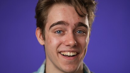 Fototapeta premium Closeup portrait of laughing smiling, happy, handsome young hipster man 20s isolated on purple color background in studio. Sincere emotions lifestyle concept.