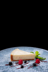 A piece of cheesecake with berries and mint