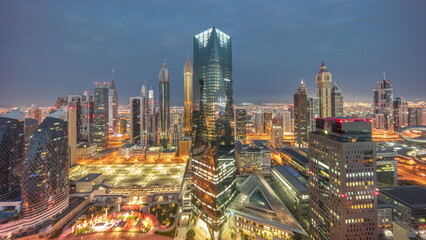 Naklejka na ściany i meble Panorama of futuristic skyscrapers in financial district business center in Dubai night to day timelapse