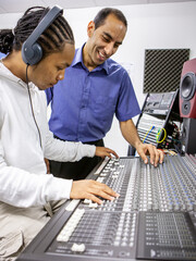 Music Students: Audio Mixer. A young sound engineer learning to use a music studio mixing desk with his teacher. From a series of related images.