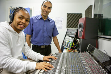 Music Students: Audio Technician. A young sound engineer learning to use a music studio mixing desk...
