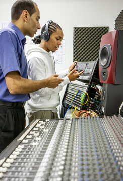 Music Students: Studio Session. A budding music producer being introduced to the recording studio by his teacher. From a series of related images.