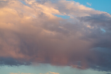 Fototapeta na wymiar Orange tinted clouds on blue sky at sunset in Minnesota. 