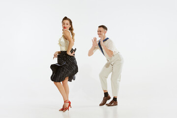 Young excited man and woman in 60s american fashion style clothes dancing retro dance isolated on...