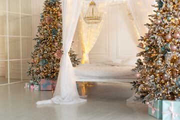 Modern white bedroom in Skandinavian style with bed with flowing white curtains and two decorated christmas tree. Concept new year and holidays. Interior design bedroom. Winter Xmas Hygge home decor	