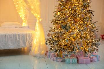 Bright glowing Christmas tree in living room in evening. Christmas tree with lights glowing garlands and gifts. Festive interior design living room with Xmas decorations. Interior design bedroom. 