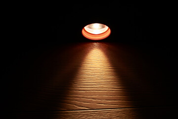 Flashlight and a beam of light in darkness. A modern led light with bright projection on dark wood...