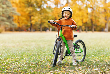 happy cheerful child boy riding a bike in Park in nature