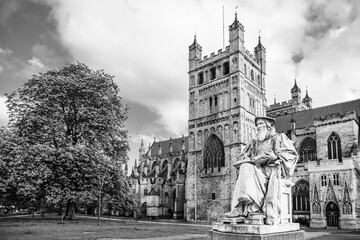 Fototapeta na wymiar Exeter, Devon, England, UK: Statue of Richard Hooker (1553 - 1600) in front of Exeter Cathedral, the Cathedral Church of Saint Peter in Exeter in black and white