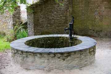 Vintage water pump at Ancient well in European village.