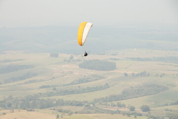 man flying a paraglider in a natural landscape