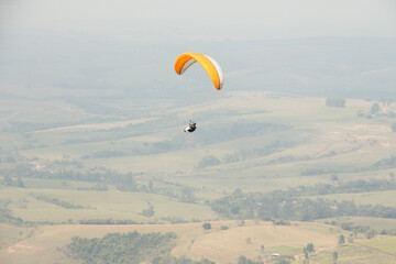 man flying a paraglider in a natural landscape