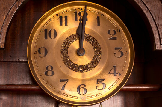 Close-up Of The Golden Face Of An Old Clock Showing Twelve O'clock (noon, Midnight).