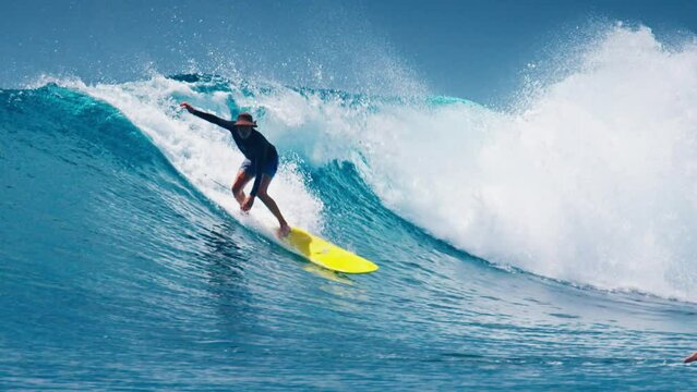 Senior Surfer Surfs The Tropical Wave In The Maldives While Other Surfers Around Keep Paddling